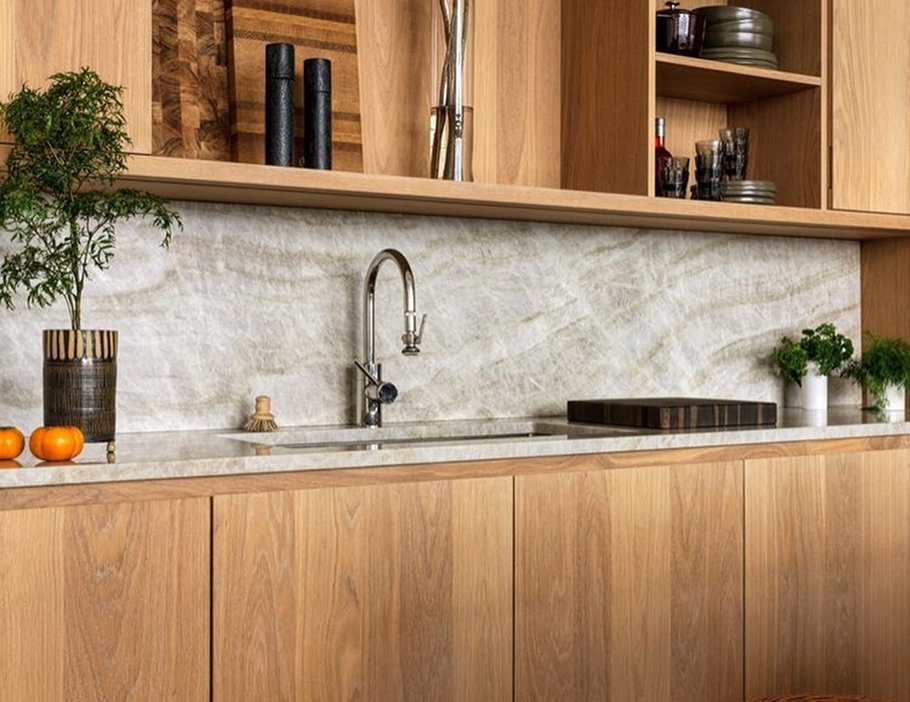 Premium Stones modern kitchen with a natural stone backsplash and wooden cabinetry.