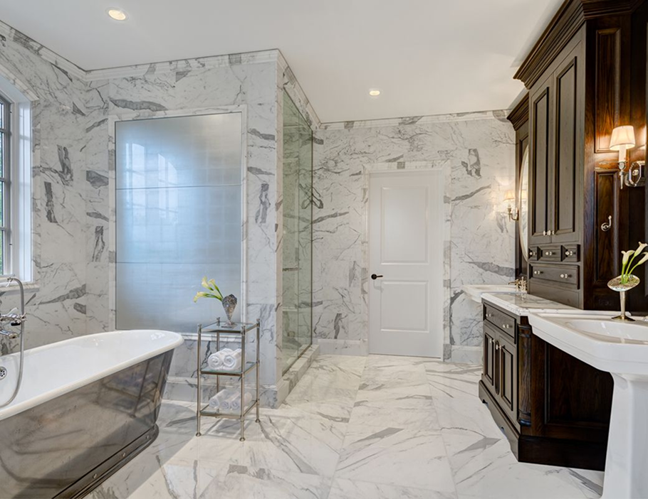 Premium Stones luxurious marble bathroom with dark wood vanity and freestanding tub.