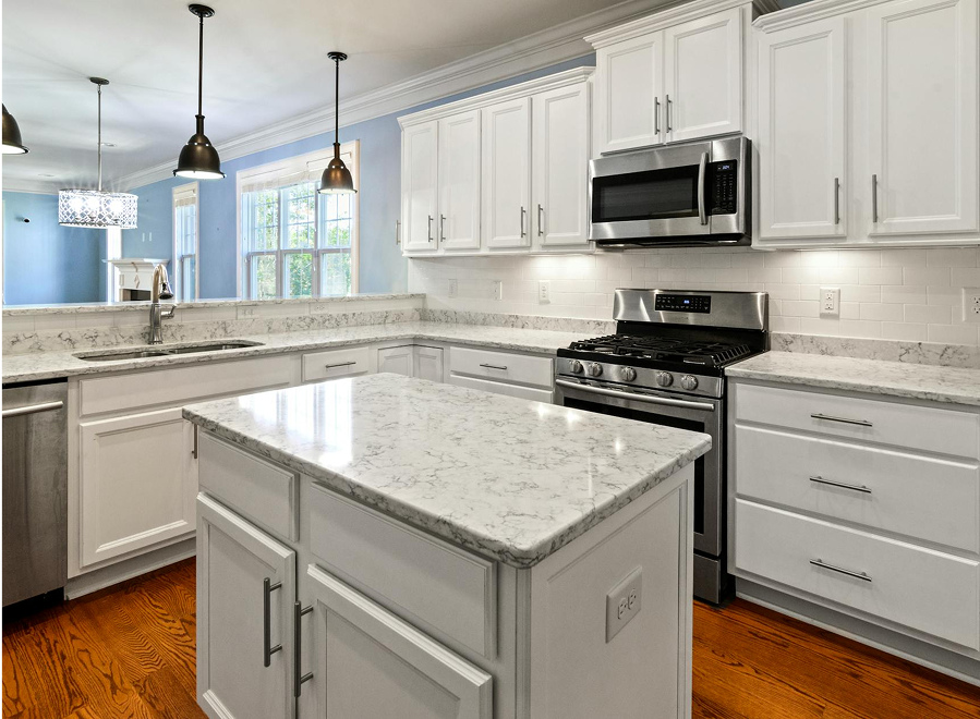 Premium Stones elegant white marble kitchen with a spacious island.