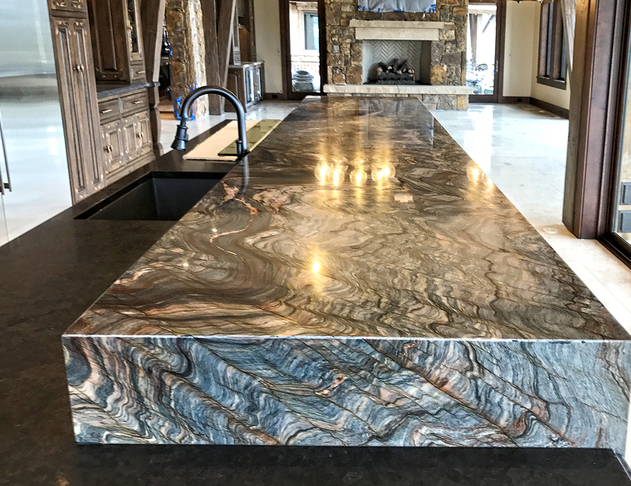 Premium Stones luxury waterfall-edge marble kitchen island with bold veining.