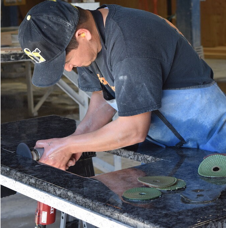 Premium Stones craftsman polishing a black granite countertop.
